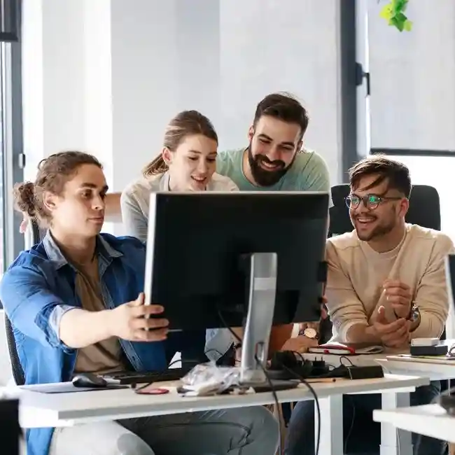 Team of casino game developers at SDLC Corp collaborating on a project in a modern office environment